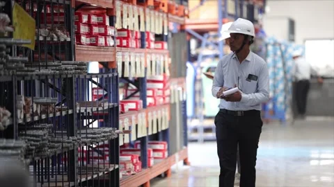 Coordinator Walking Through Warehouse Aisle Carrying Notepad for Stock Stock Footage 328154240