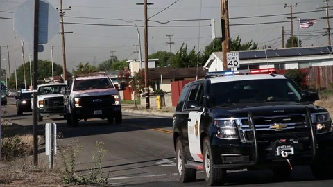 Cop and fire vehicle covered in red chemicals leave fire scene Stock Footage 114413659