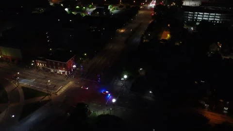Cop car night time traffic stop in otherwise tranquile city 4K Stock Footage 324832474