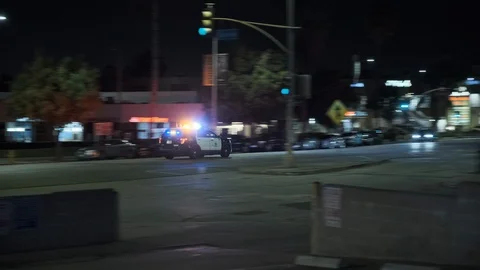 Cop Car Racing Down Los Angeles Street at Night Stock Footage 125837876