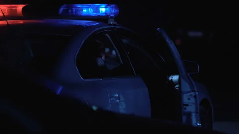 Cop getting out of patrol car, checking victim lying on street, crime scene Stock Footage 100549939