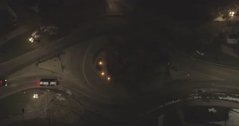 Cop ghost car chasing a mustang at a roundabout - Night - Aerial shot Stock Footage 146402683