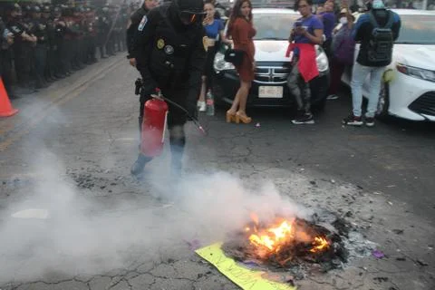 Cop puts fire out Stock Photos