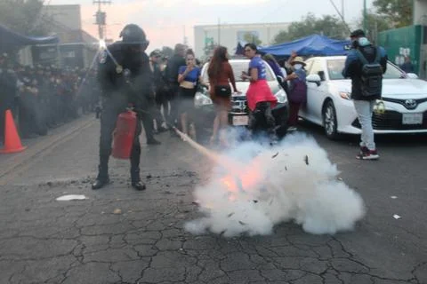 Cop puts fire out in protest Stock Photos