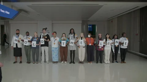 COP28, Dubai: A chain of demonstrators hold the letters to “hold the line” 動画素材 288467444