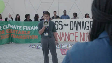COP28, Dubai: Demonstrators sing protest slogan to finance loss and damage 動画素材 288470278