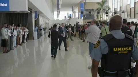COP28, Dubai: A lieutenant in charge of security watches a silent demonstration. 動画素材 288460088