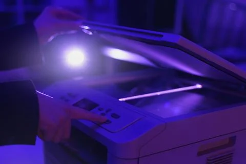 Copier scanner with a bright light inside. Office hazards concept Stock Photos