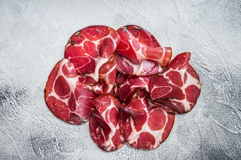 Coppa Cured ham on kitchen table. White background. Top view Stock Photos