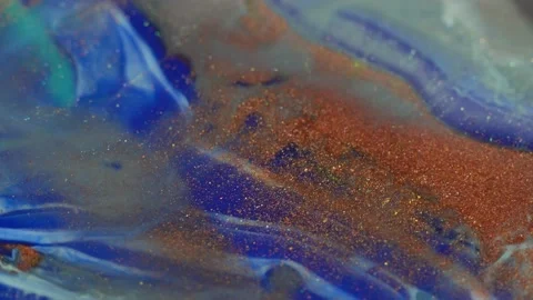 Copper and blue liquid flowing paint with gold shiny metallic particles macro Stock Footage 154685881