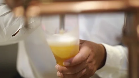 Copper beer dispenser with blurred bartender poured cold draft beer Video stock 121390823