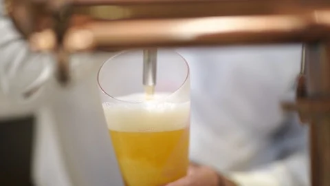 Copper beer dispenser with blurred bartender poured cold draft beer Stock Footage 121390825