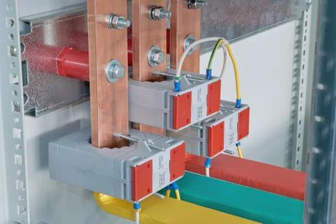 Copper busbars with current transformers on them in an electric Cabinet. Stock Photos