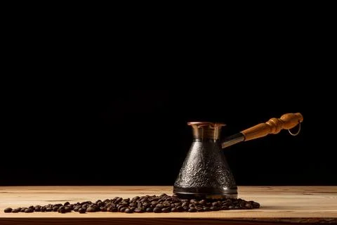 Copper cezve with coffee on the table Stock Photos