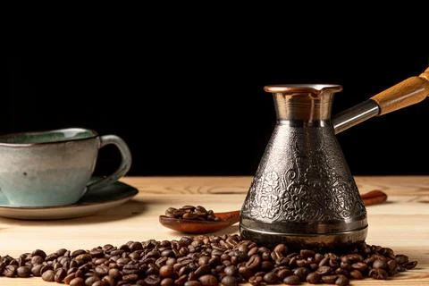 Copper cezve with coffee on the table Stock Photos
