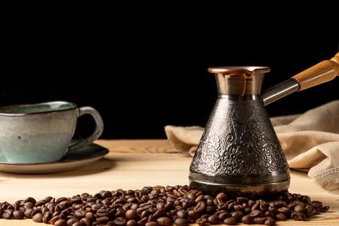 Copper cezve with coffee on the table Stock Photos