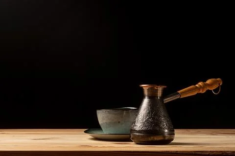 Copper cezve with coffee on the table Stock Photos