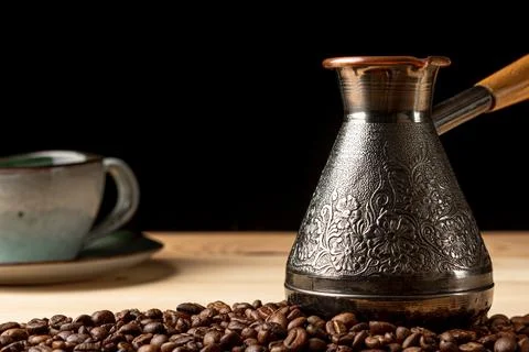 Copper cezve with coffee on the table Stock Photos