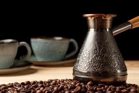 Copper cezve with coffee on the table Stock Photos
