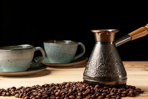 Copper cezve with coffee on the table Stock Photos