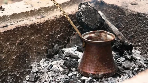 Copper coffee pot on hot embers. Traditional Turkish coffee. Stock Footage 138406178