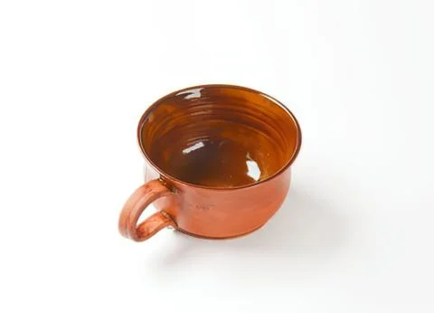 Copper colored metal cup with handle on white Photos