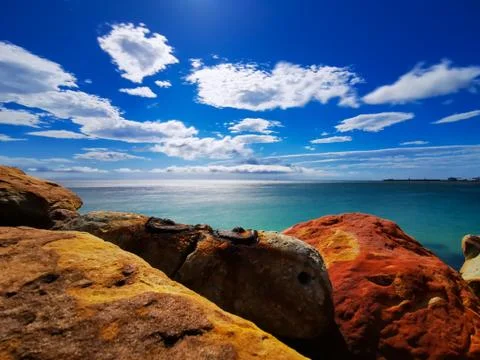 Copper colored rocks with blue sky Stock Photos