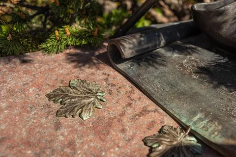 Copper forged maple leaf on granite stone Stock Photos