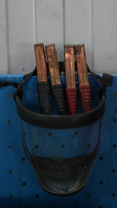 Copper jumper cable clamps hanging inside a clear face shield. Stock Footage 343889977