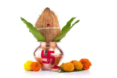 Copper Kalash with coconut, mango leaf, Haldi, kumkum and sweets with marigol Stock Photos