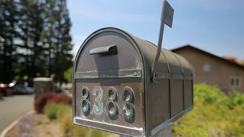 Copper metal mailbox with stone base by house. Mail flag up D Stock Footage 110878931