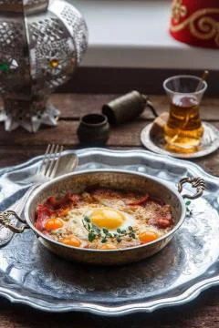 Copper pan with fried eggs and sausages, turkish style Stock Photos