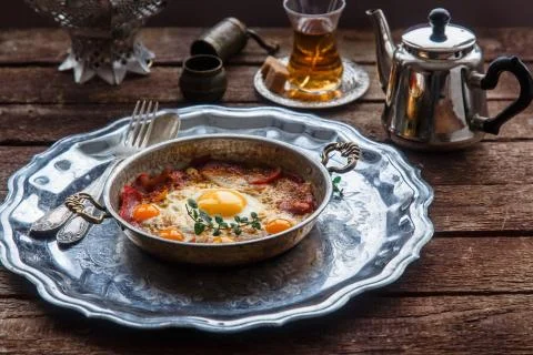 Copper pan with fried eggs and sausages, turkish style Stock Photos