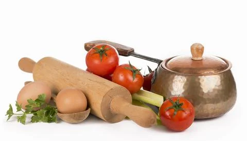 Copper pan, rolling pin, spoons and different raw vegetables on a white backg Stock Photos
