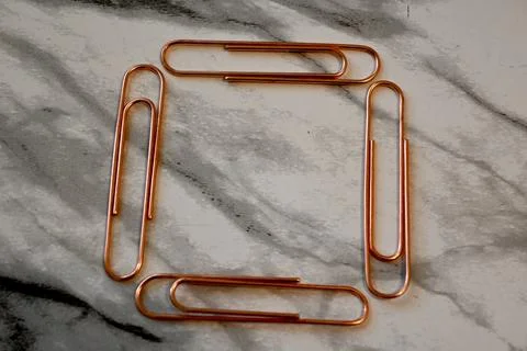 Copper paper clips arranged in a frame Stockfoto's