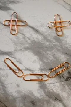 Copper paper clips on marble background 스톡 사진