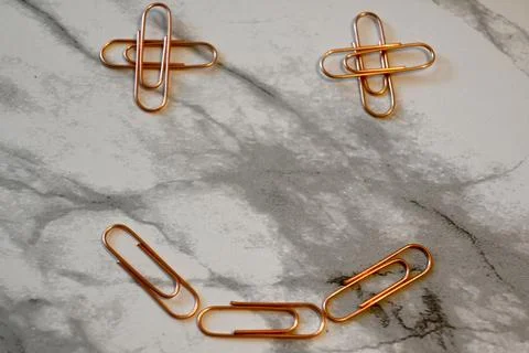 Copper paper clips on marble surface Stockfoto's