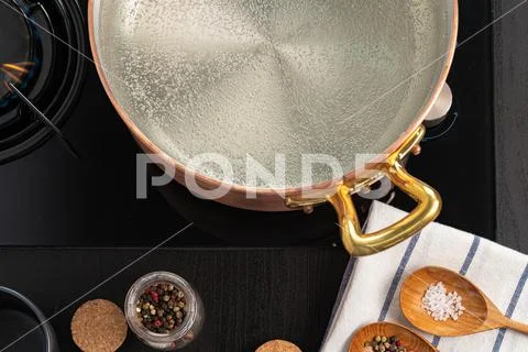 Copper pot with boiling water on a gas stove Stock Photos