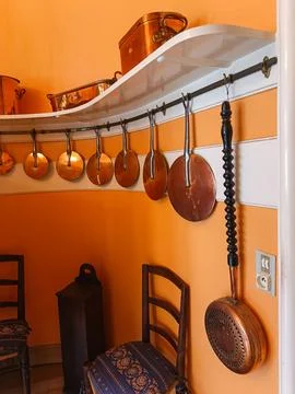 Copper pots and pans on kitchen rack Stockfoto's