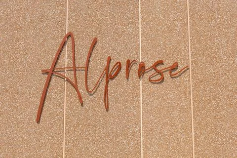 Copper Script Sign Across Warm Textured Wall, Elegant Handwritten Word Disp.. Foto stock