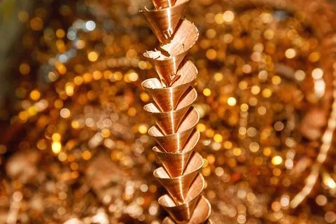 Copper shavings. Copper processing on CNC machines in production. Stock Photos