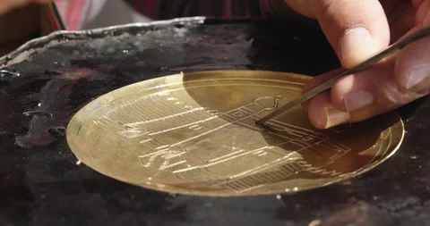 Copper-smith engraving patterns on a metal plate. Handmade Uzbek souvenirs Stock Footage 290233086