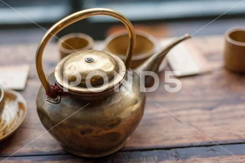 Copper teapot on a wooden table Stock Photos