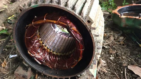 Copper Winding Stator inside an open electric motor casing resting on dirt groun 動画素材 344792519