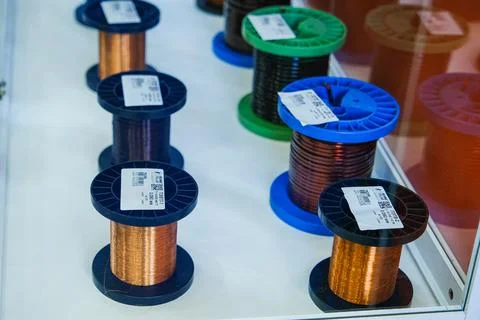 Copper wire spools displayed on shelf at electrical industrial exhibition. Stockfoto's