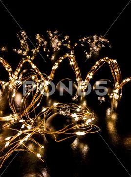 Copper wire string lights on black background Stock Photos