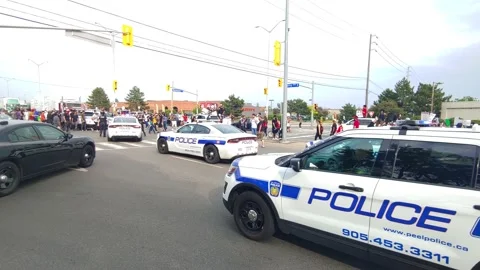 Cops disembarking and walking towards colleagues officers stuck in rally Stock Footage 133975197