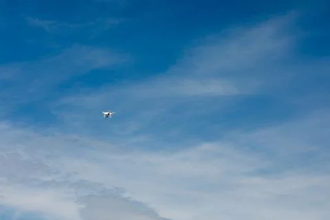 Copter with a camera on the background of a blue sky with clouds. Stock Photos