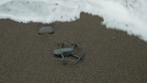 Copter fall in sea water. Waves wash the drone Stock Footage 105187561