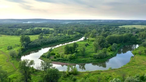 A copter flies back from a plain with a river bend. Stock Footage 116688397